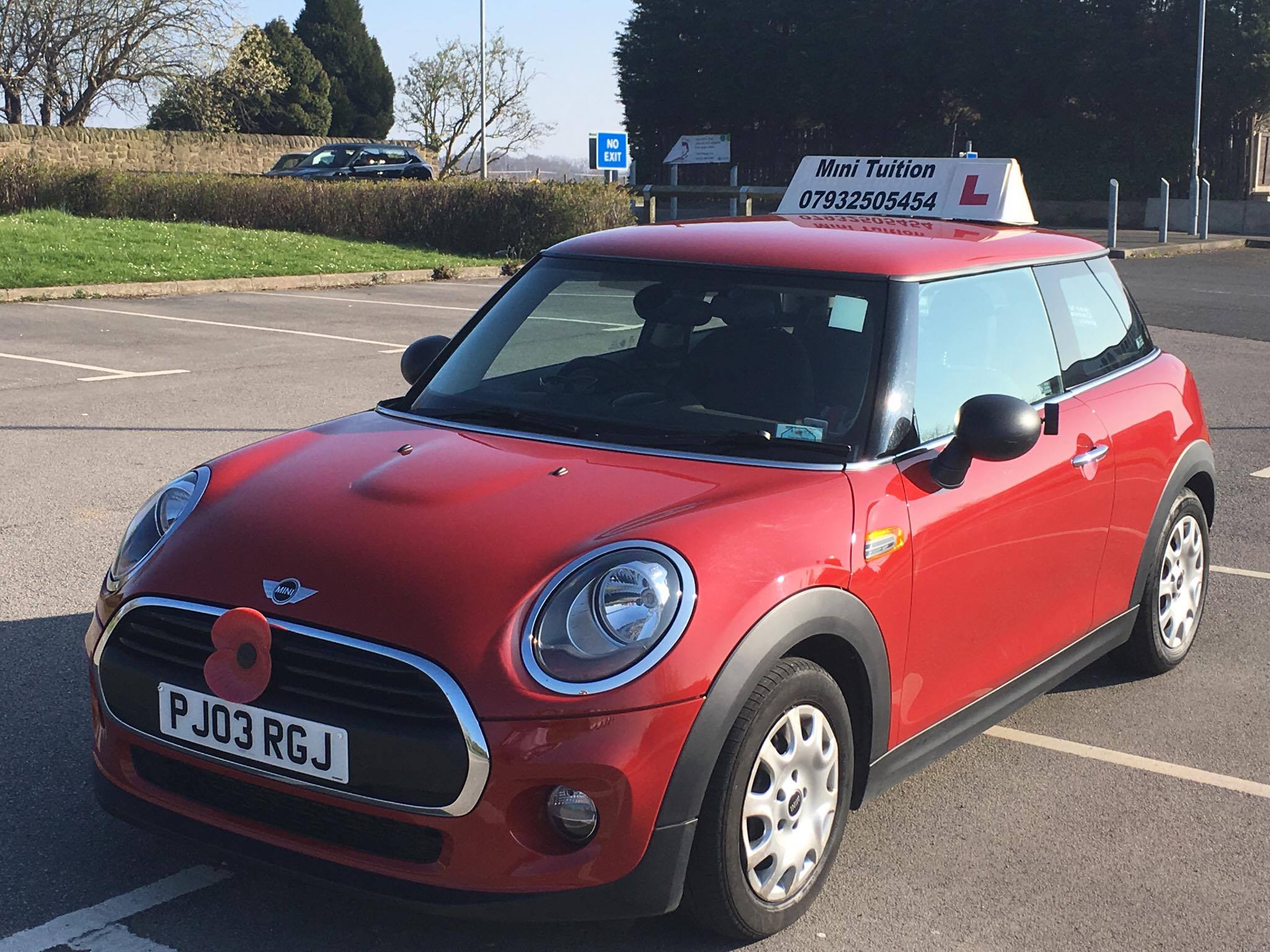 Mini Tuition's red learner car, with its school name and telephone number on the roof sign