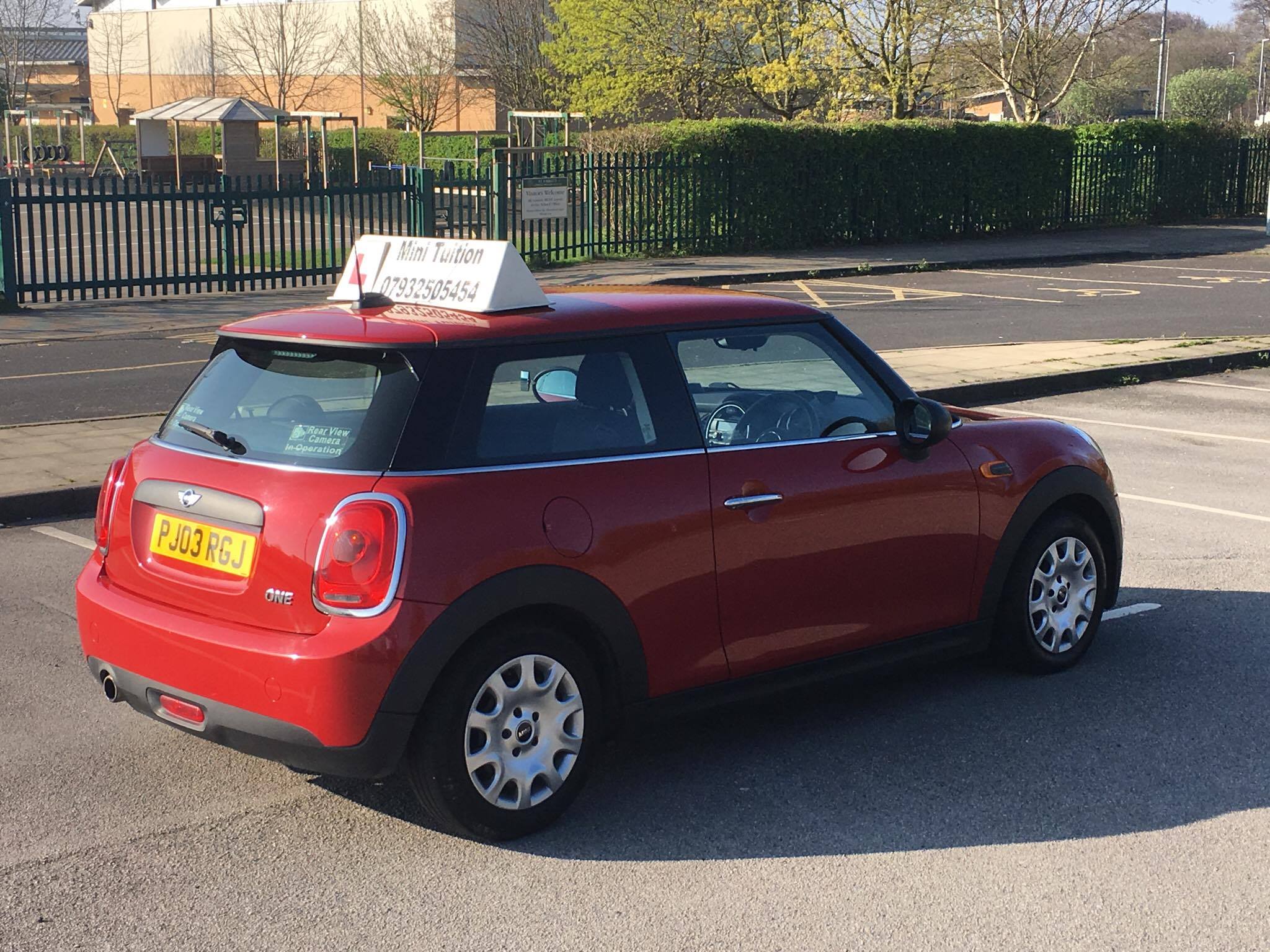 Rear three-quarter view of Mini Tuition's red learner car